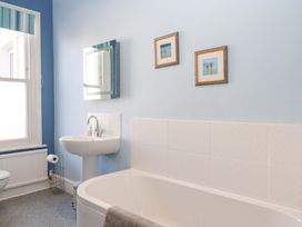 A bathroom with a bathtub and sink at Avenue Park Villa in Torquay