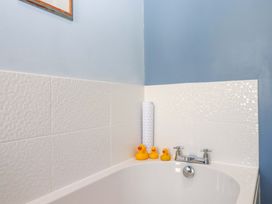 A bathtub with rubber ducks and towels at Avenue Park Villa in Torquay
