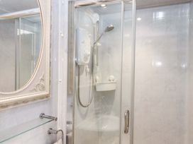 A bathroom with a shower and mirror at Avenue Park Villa in Torquay