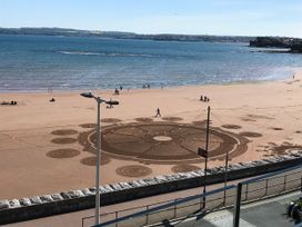A beach with sand patterns and people at Avenue Park Villa in Torquay