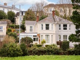 A house with windows and greenery at Avenue Park Villa in Torquay