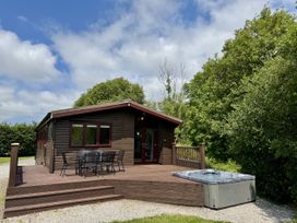 A cabin with a deck and hot tub at Willow Lodge in Constantine near Falmouth