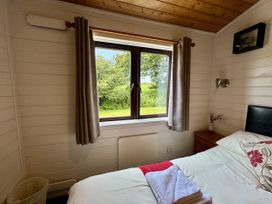 A bedroom with a bed and window at Willow Lodge in Constantine near Falmouth