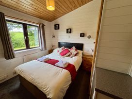 A bedroom with a bed and window at Willow Lodge in Constantine near Falmouth