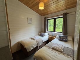 A bedroom with two single beds and a window at Willow Lodge in Constantine near Falmouth