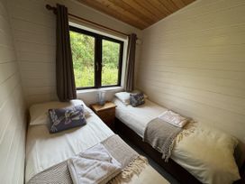 A bedroom with twin beds and a window at Willow Lodge Constantine near Falmouth