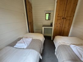 A bedroom with twin beds and a table at Willow Lodge in Constantine near Falmouth