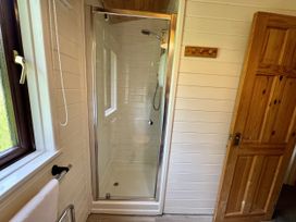 A bathroom with a shower enclosure and towel rail at Willow Lodge Constantine near Falmouth