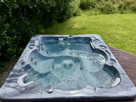 A hot tub with water situated in an outdoor area at Willow Lodge in Constantine near Falmouth