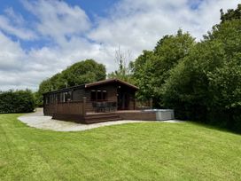 A log cabin with a deck and hot tub at Willow Lodge Constantine near Falmouth