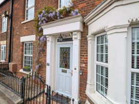 A front door with a window and flowers at Springfield in Hempton near Fakenham