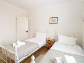 A bedroom with two single beds and a bedside table at Springfield in Hempton near Fakenham