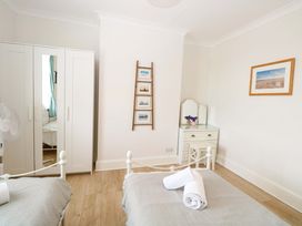 A bedroom with two beds and a wardrobe at Springfield in Hempton near Fakenham