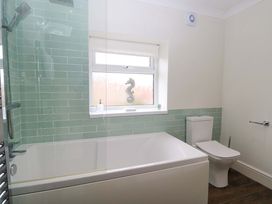 A bathroom with a bathtub, toilet and shower at Springfield in Hempton near Fakenham