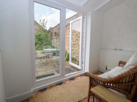 A sunroom with an armchair and a table at Springfield in Hempton near Fakenham