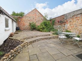 A garden with a patio and seating area at Springfield in Hempton near Fakenham