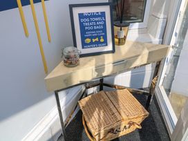An entryway table with a notice frame, a jar, and a basket at Apt 5 @ Hunter's Quay in Bridlington