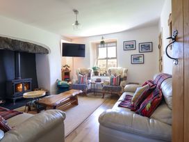 A living room with a fireplace and seating area at Cefn Nannau near Ty-nant Cerrigydrudion