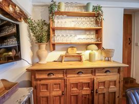 A wooden cabinet with glassware and a vase at Cefn Nannau Ty-nant near Cerrigydrudion
