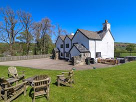 An outdoor area with a house and chairs at Cefn Nannau Ty-nant near Cerrigydrudion