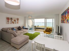 A living room with a sofa and table at Welymora Pwllheli