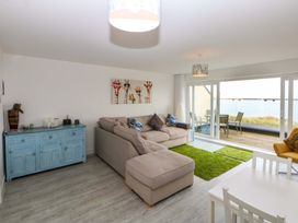 A living room with a sofa and dining table at Welymora Pwllheli