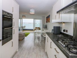 A kitchen with appliances and dining area at Welymora Pwllheli