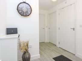 A hallway with a clock and a cabinet at Welymora in Pwllheli