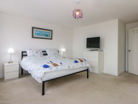 A bedroom with a bed and television at Welymora in Pwllheli