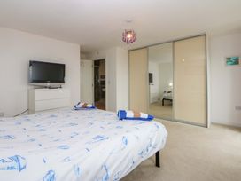 A bedroom with a bed and television at Welymora Pwllheli