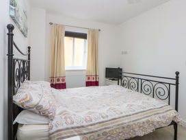 A bedroom with a bed and a tv at Welymora in Pwllheli