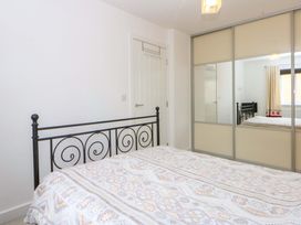 A bedroom with a bed and mirror at Welymora in Pwllheli