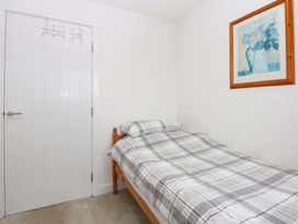 A bedroom with a bed and a door at Welymora, Pwllheli