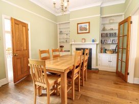 A dining room with a wooden table and chairs at Tilly's Retreat in Hunstanton