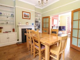 A dining room with a wooden table and chairs at Tilly's Retreat in Hunstanton