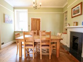 A dining room with a wooden table and chairs at Tilly's Retreat in Hunstanton