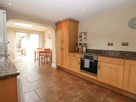 A kitchen with an oven and a dining table at Tilly's Retreat in Hunstanton