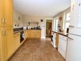 A kitchen with oak cabinets and appliances at Tilly's Retreat in Hunstanton