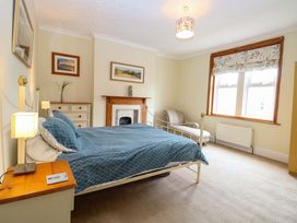 A bedroom with a bed and chair at Tilly's Retreat Hunstanton