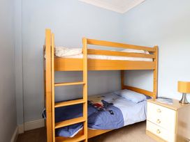 A bunk bed and bedside table in a bedroom at Tilly's Retreat in Hunstanton