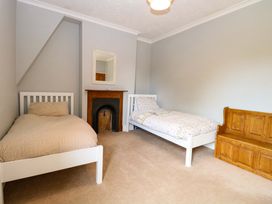 A bedroom with two single beds and a wooden bench at Tilly's Retreat in Hunstanton