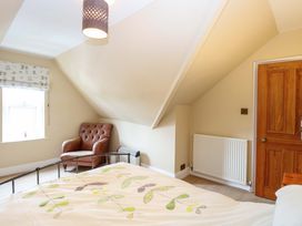 A bedroom with a bed and an armchair at Tilly's Retreat in Hunstanton