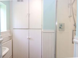 A bathroom featuring a shower and cupboard at Tilly's Retreat in Hunstanton