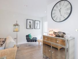 A living room with a clock and artwork at Seaspell Beach House in Constantine Bay