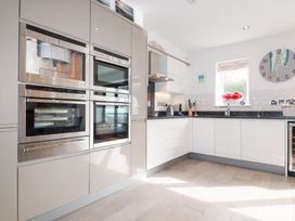A kitchen with built-in ovens, sink, and cabinets at Seaspell Beach House in Constantine Bay
