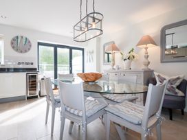A dining room with a glass table and chairs at Seaspell Beach House in Constantine Bay