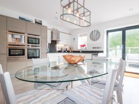 A kitchen with a dining table and modern appliances at Seaspell Beach House in Constantine Bay