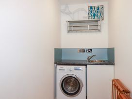 A laundry room with a washing machine and sink at Seaspell Beach House in Constantine Bay