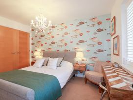A bedroom with a bed and a decorative fish wall at Seaspell Beach House in Constantine Bay