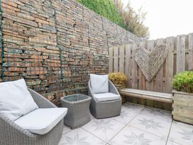 An outdoor space with chairs, a table, and a bench at Seaspell Beach House in Constantine Bay